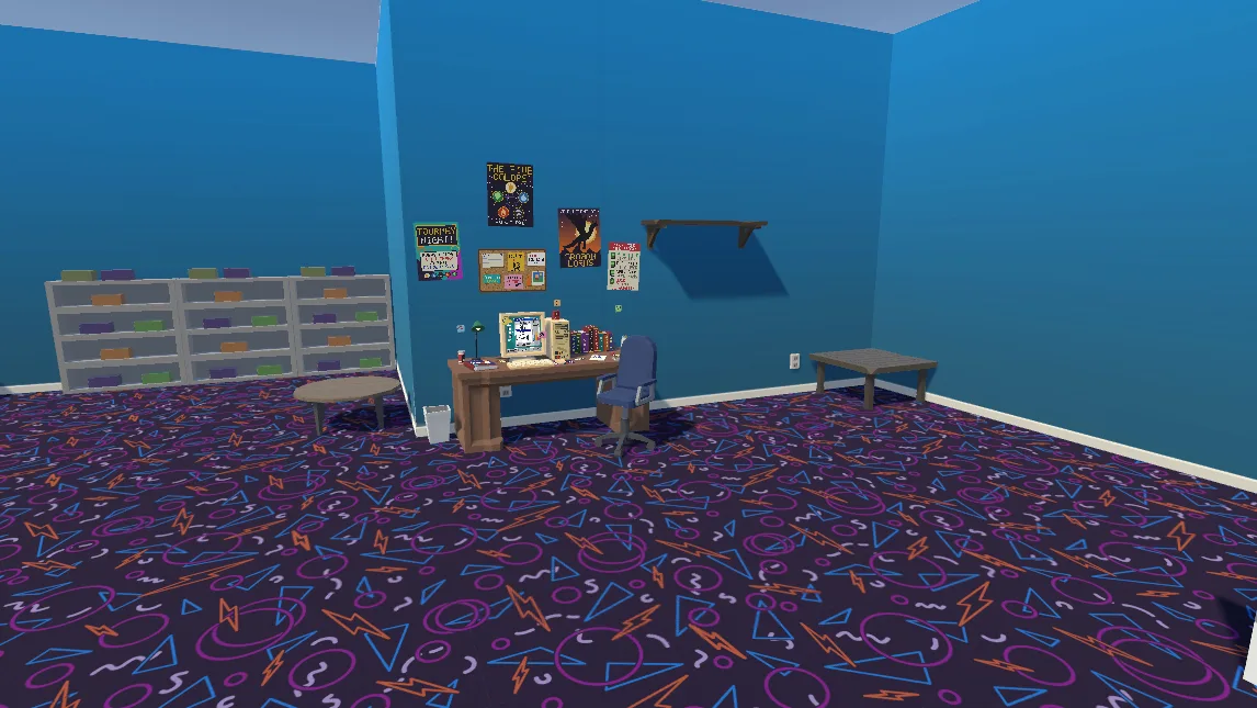 The computer desk in the corner of the shop, with posters and a corkboard on the wall